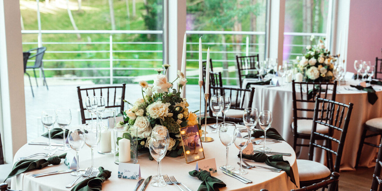 Gražus vestuvinis apvalios formos stalas su gražiomis gėlėmis